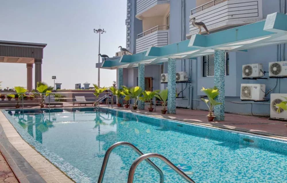 Outdoor swimming pool and sun deck at Hotel Prabhupada Puri